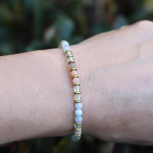 Woman wearing dainty aquamarine and sunstone bracelet