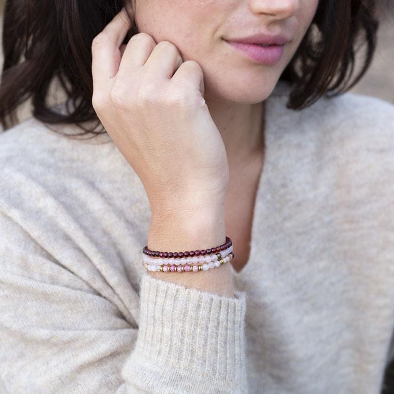 Woman wearing dainty Garnet and Rose Quartz bracelet set