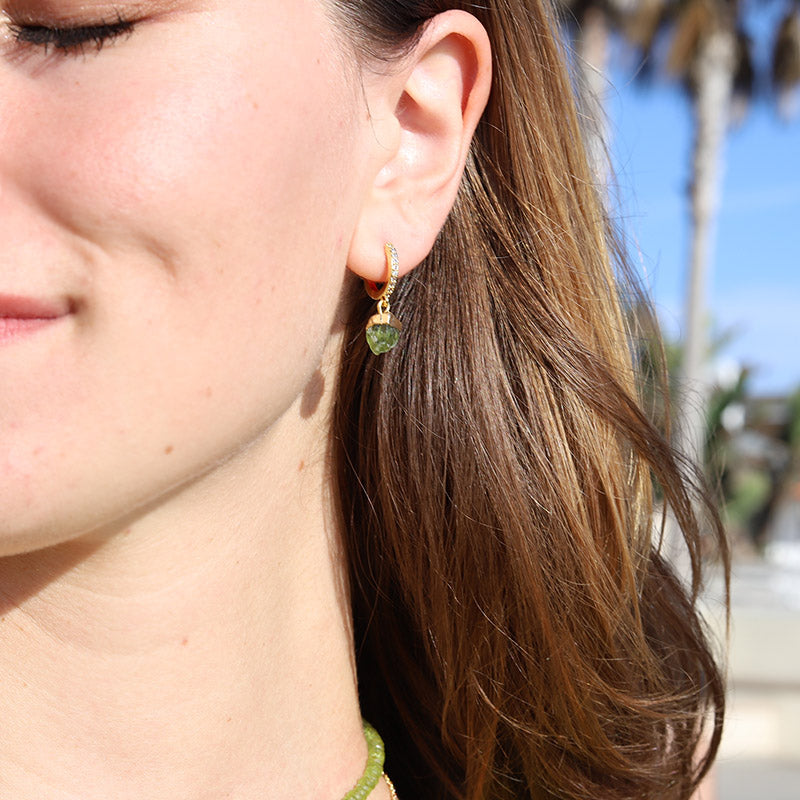 Model wearing raw peridot earrings